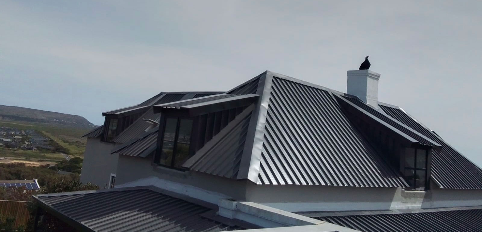 Completed dark metal roof on a Cape property